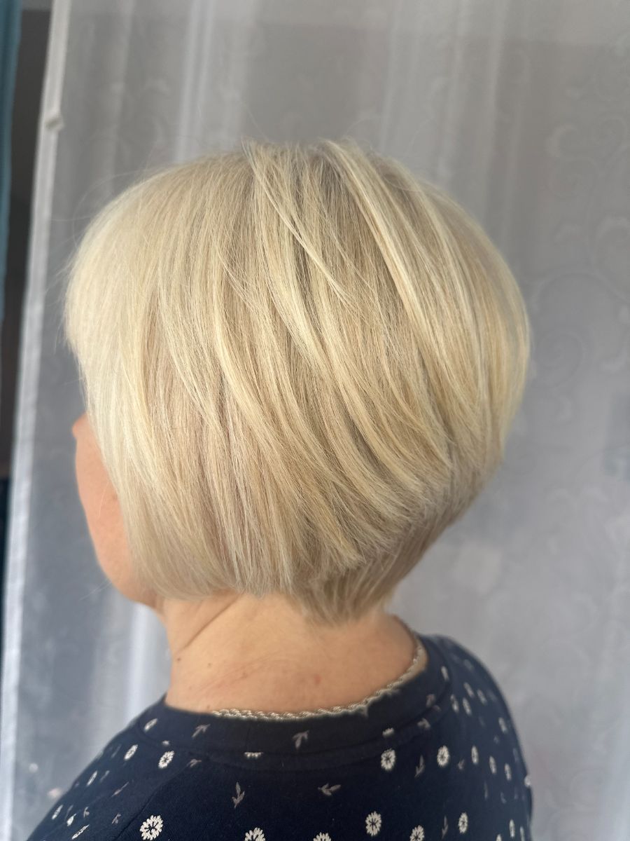 Coupe carré plongeant, blond platine, vue de dos — réalisation Iris Azur
